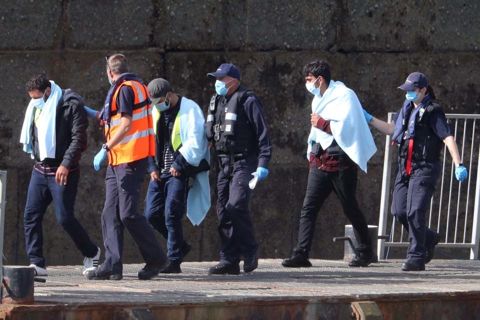 A group of people thought to be migrants are brought into Dover, Kent, by Border Force officers following a small boat incident in the Channel (PA)