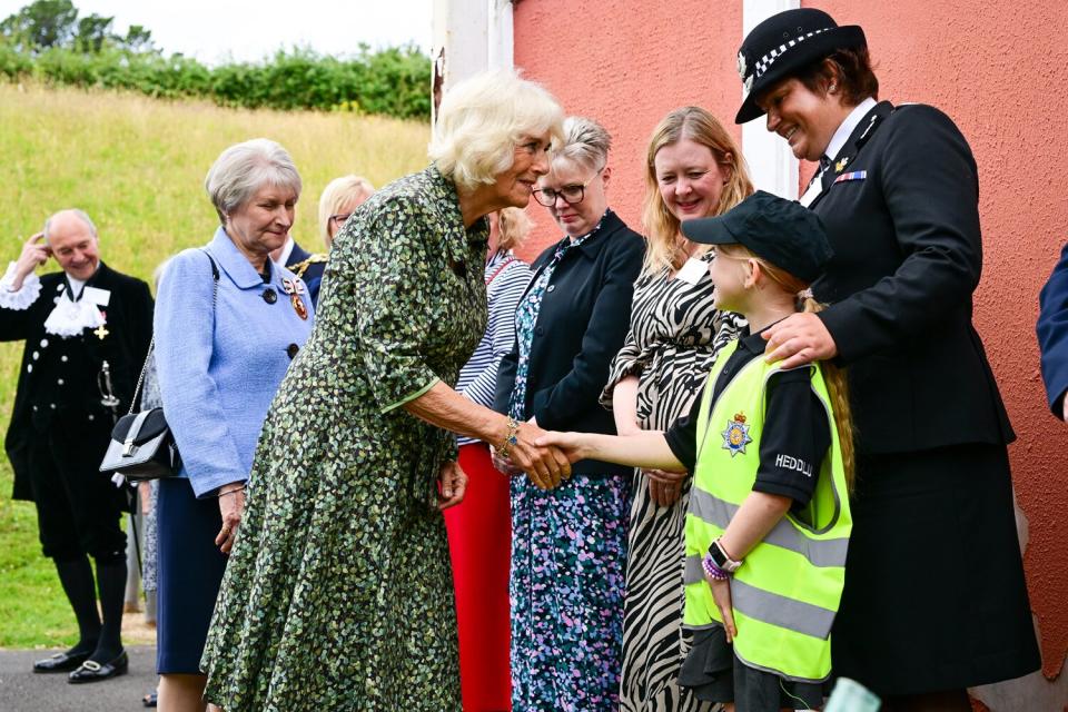 Camilla, Duchess of Cornwall meets one of the 'Little Police' who shadow real police during the day during her visit to Millbrook Primary School on July 06, 2022 in Newport, Wales