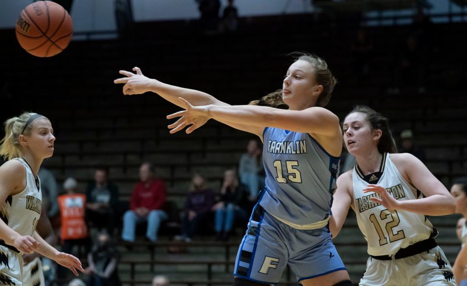 Franklin Grizzly Cubs Erica Buening (15) passes the ball against Washington Lady Hatchets forward Olivia Gilley (12) on Wednesday, Dec. 29, 2021, at the The New Castle Fieldhouse in New Castle. The Franklin Grizzly Cubs defeated the Washington Hatchets, 58-47.