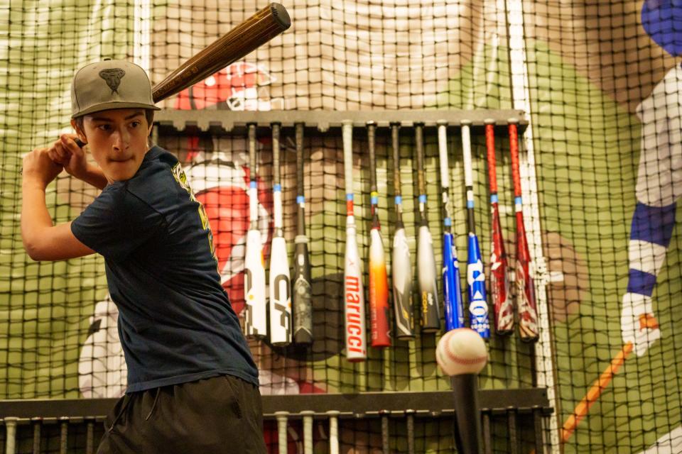 Rafael Garcia hits a baseball of a tee as he shops for a bat at Scheels at the Chandler Fashion Center on Sept. 30, 2023, in Chandler.