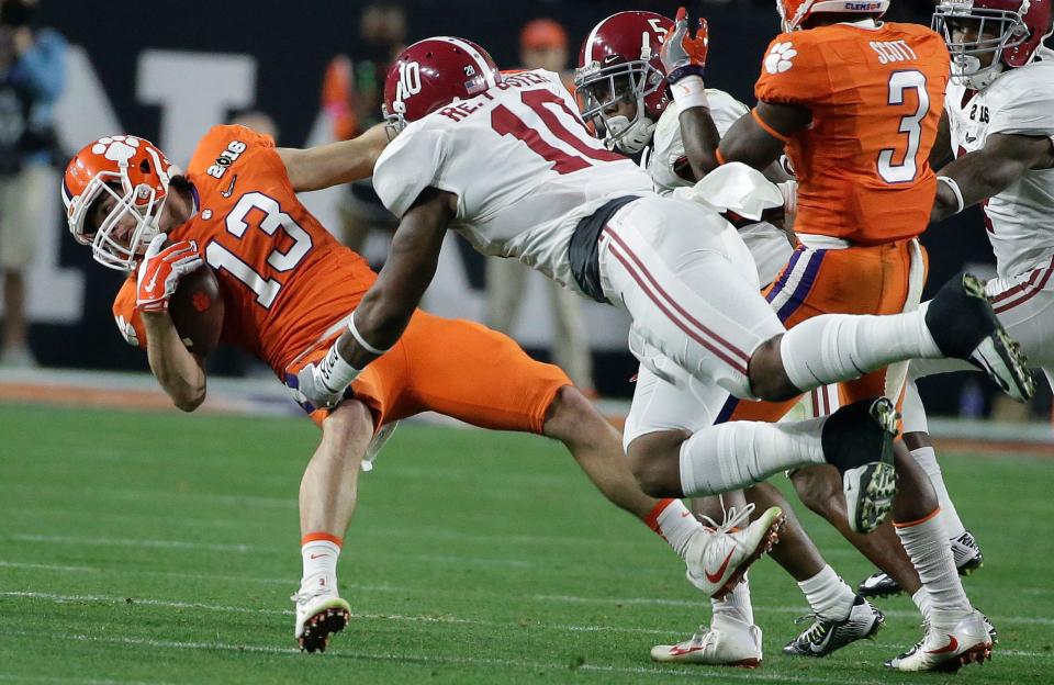 Alabama's Reuben Foster tackles Clemson's Hunter Renfrow during the first half of the College Football Playoff title game Monday, Jan. 11, 2016, in Glendale, Ariz.