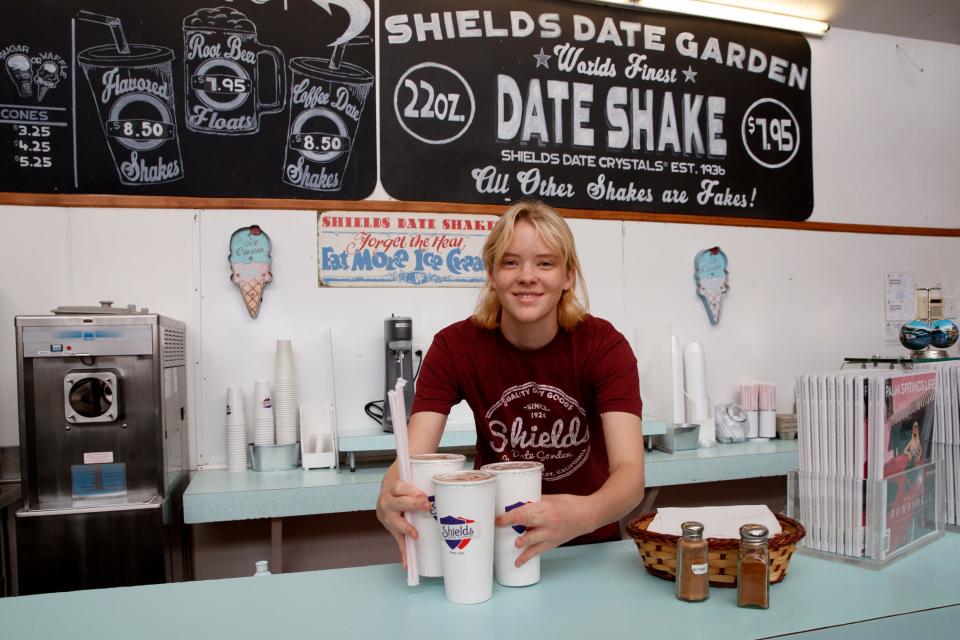 Ayden Billman serves three date shakes to customers at Shields Date Garden in Indio, Calif., on July 27, 2022. 