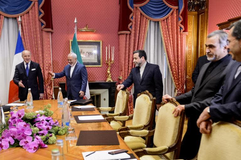 French Foreign Minister Laurent Fabius (L) gestures towards his Iranian counterpart Mohammad Javad Zarif (2nd L) as they take their seats at the opening of a bilateral meeting on nuclear talks on March 28, 2015 in Lausanne, Switzerland