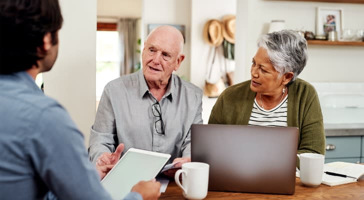 A senior couple meeting with a financial advisor to optimize their retirement plan for tax breaks.