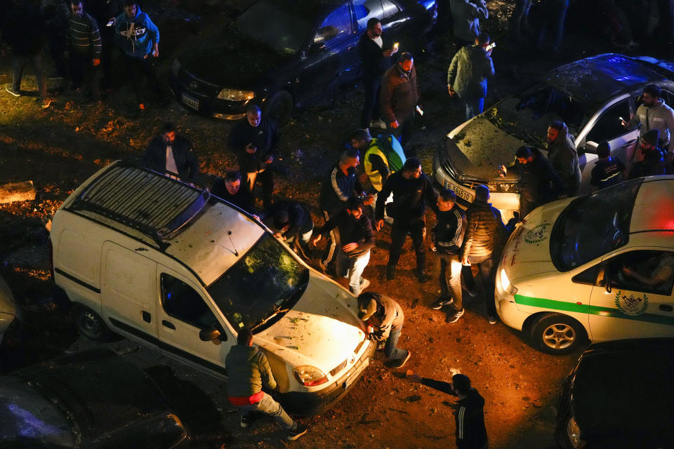 People remove a damage car following a massive explosion in the southern suburb of Beirut, Lebanon, Tuesday, Jan. 2, 2024. (AP Photo/Hassan Ammar)