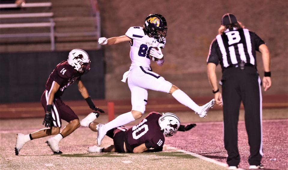 Wylie receiver Harrison Heighten leaps over Brownwood's Case Markham (10) and into the end zone for a 38-yard touchdown pass from K.J. Long. The score gave the Bulldogs a 30-17 lead with seven seconds left in the first half. Wylie beat the Lions 30-24 in the season opener last season at Gordon Wood Stadium in Brownwood.