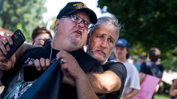 PHOTO: Jon Stewart hugs Tim Hauser, an Air Force veteran, at a rally to call on the Senate to pass the Pact Act, which aims to expand health care and benefits to veterans exposed to toxins while serving, outside the Capitol in Washington, Aug., 2, 2022. (Tom Williams/CQ Roll Call via AP Images)