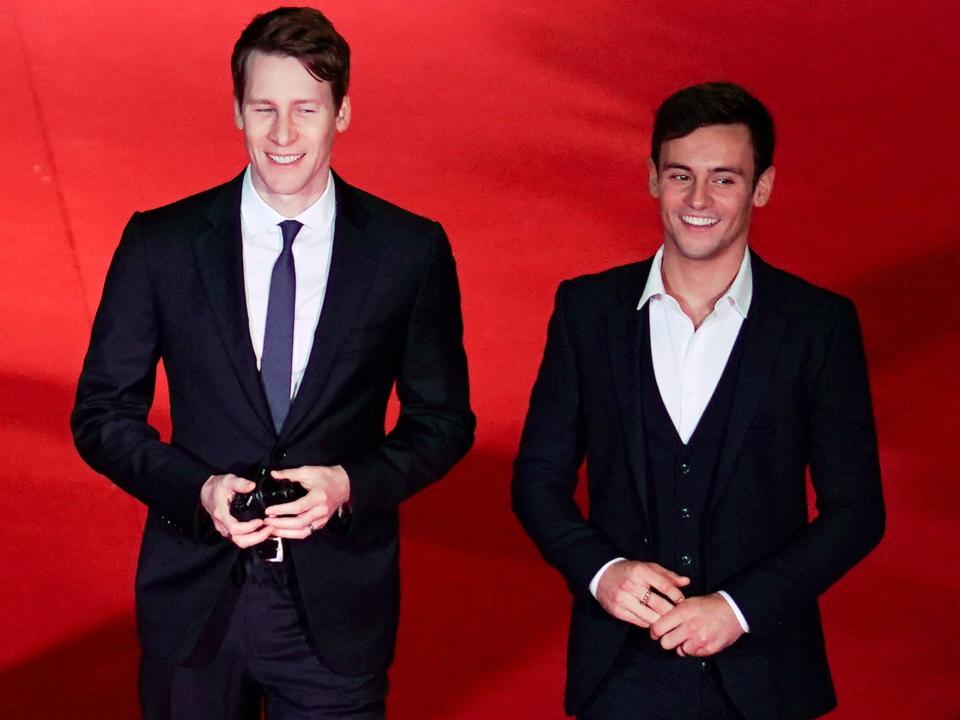 Dustin Lance Black and Tom Daley in 2017 in suits on a red carpet