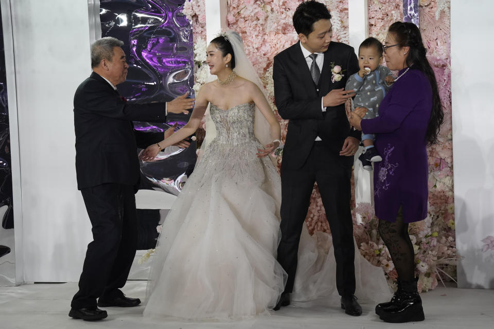 Bride Chen Yaxuan and groom Dou Di greet guests during a wedding banquet in Beijing on Saturday, Dec. 12, 2020. Lovebirds in China are embracing a sense of normalcy as the COVID pandemic appears to be under control in the country where it was first detected. (AP Photo/Ng Han Guan)