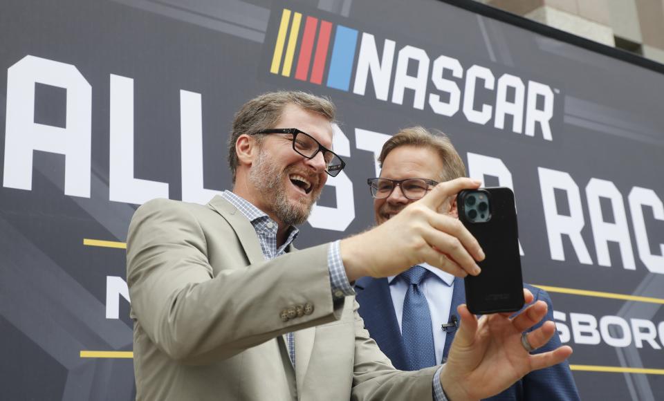 FILE - Dale Earnhardt Jr., left, laughs with Speedway Motorsports President and CEO Marcus Smith as they record a video after a press conference, Thursday, Sept. 8, 2022, in Raleigh, N.C., announcing that the a NASCAR All-Star Race will be held at North Wilkesboro Speedway in May 2023. (Ethan Hyman/The News & Observer via AP)