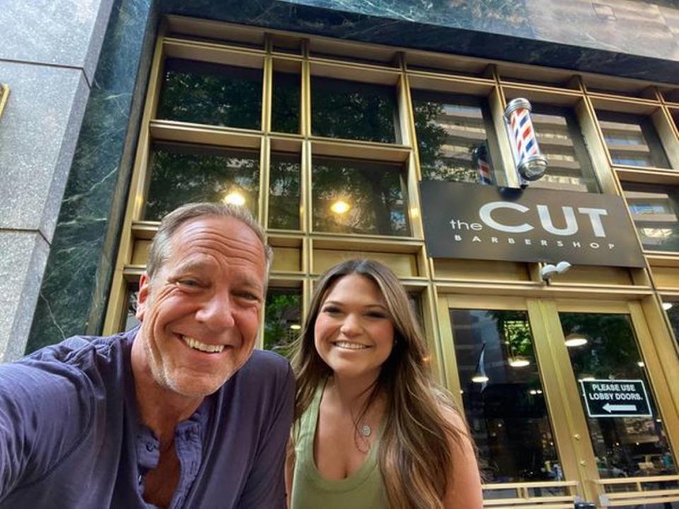 “Dirty Jobs” host Mike Rowe takes a selfie with Allyssa Hagaman, the stylist from Harrisburg, NC, who saved his hair at The CUT Barbershop in uptown Charlotte on Friday, May 20, 2022.