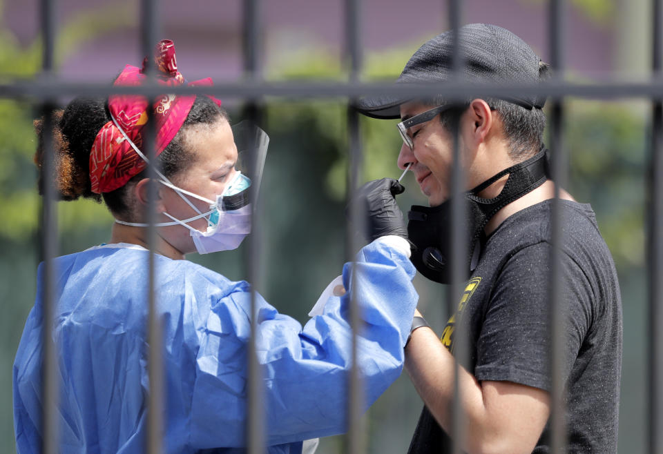 Jorge Garcia of New Orleans gets tested for COVID-19 at a mobile testing site in New Orleans, Wednesday, July 8, 2020. Testing sites in New Orleans have been running out of their daily allocation of tests within minutes of opening. (AP Photo/Gerald Herbert)