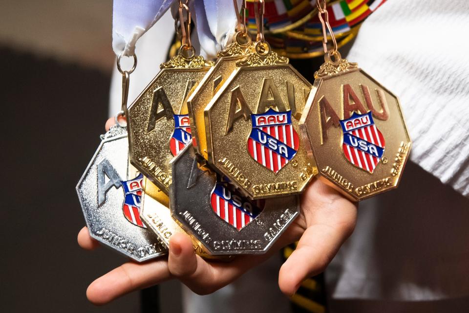 Joshua Aguirre holds a few of his most recent medals from the AAU Junior Olympic Games, at his home in Lebanon. Aguirre has been to three Junior Olympic Games for taekwondo and has won 17 gold medals and three silver medals.