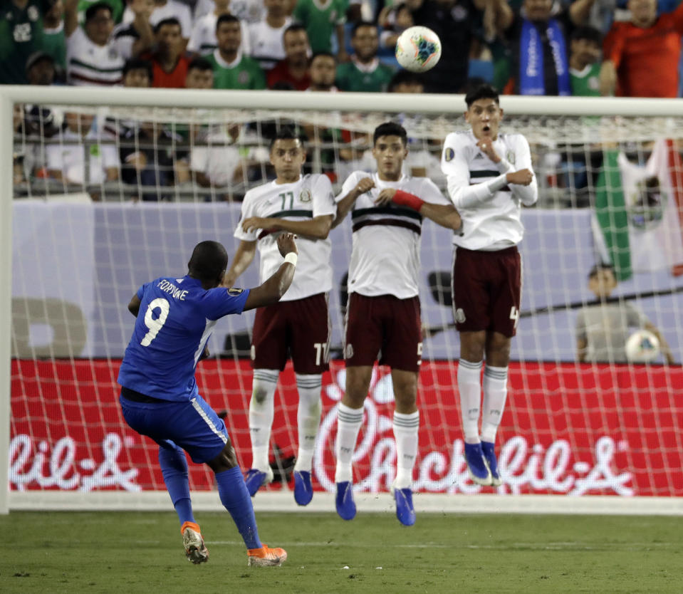 Martinique's Kevin Fortune (9) takes a free kick over Mexico players Roberto Alvarado (11), Diego Reyes (5) and Edson Alvarez (4) during the first half of a CONCACAF Golf Cup soccer match in Charlotte, N.C., Sunday, June 23, 2019. (AP Photo/Chuck Burton)