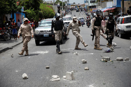 Haitian National Police officers clear a street from rocks during a protest in Port-au-Prince, Haiti, July 14, 2018. REUTERS/Andres Martinez Casares