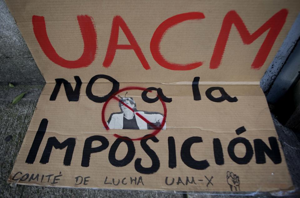 In this photo taken Thursday, Oct. 11, 2012, an image of Esther Orozco, rector of the Autonomous University of Mexico City, UACM , is pasted to a protest poster, that reads in Spanish; "UACM, no to the the imposition," outside the Mexico City campus. Students fed up with lost class time are seizing back their campuses, showing little nostalgia for Mexico's radical traditions. This month, about 100 students at Mexico City's Autonomous University rushed the gates of their seized campus and briefly forced out striking students, who later returned with a pickup truck to bash in the gates and retake the school. The two sides are now in talks to end the standoff. (AP Photo/Eduardo Verdugo)