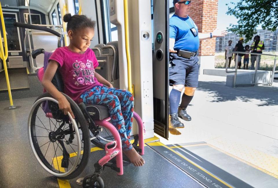 La usuaria de silla de ruedas Desire Holmes, de 7 años, usa una rampa para salir del nuevo tren ligero de piso bajo S700 en la estación Township 9 de Sacramento el miércoles. "Cuando lo vi dije: 'Perfecto'", dijo Lisa Silas, amiga de la familia Holmes, refiriéndose a la rampa de entrada de piso bajo. "Pueden deslizarse fácilmente como el resto de nosotros".