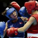 North Korea's Kim Hye Song, left, and Russia's Elena Savelyeva, fight during the women's flyweight boxing competition at the 2012 Summer Olympics, Sunday, Aug. 5, 2012, in London. (AP Photo/Ivan Sekretarev)