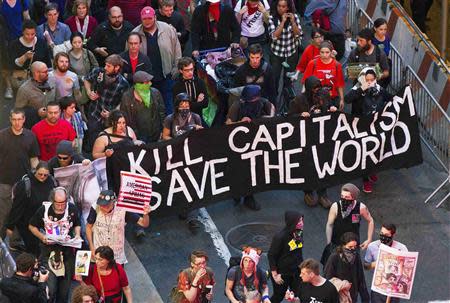 Members from the Occupy Wall Street movement carry signs and banners as they march down Broadway during a May Day demonstration in New York in this May 1, 2012, file photo. REUTERS/Lucas Jackson/Files