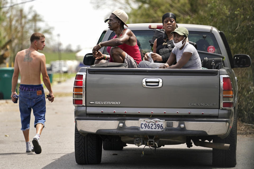 Linda Smoot, right, Rakisha Murray, center, and Bernie Murray who evacuated from Hurricane Laura in a pickup truck with eight others, react to the scenes of devastation as they return to see their homes for the first time, in Lake Charles, La., in the aftermath of the hurricane, Sunday, Aug. 30, 2020. (AP Photo/Gerald Herbert)