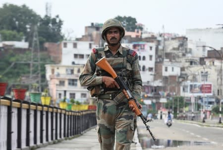 An Indian army soldier patrols on a bridge during restrictions in Jammu