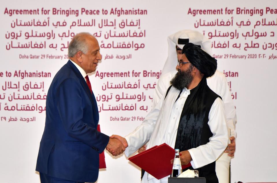 Zalmay Khalilzad, the U.S. special representative for Afghanistan reconciliation, and Taliban co-founder Mullah Abdul Ghani Baradar sign a peace agreement in a ceremony in the Qatari capital, Doha.