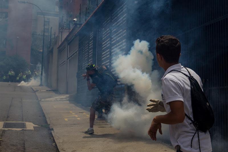 Manifestantes evaden gases lacrimógenos lanzados por miembros de la Policía Nacional Bolivariana (PNB) durante una manifestación este miércoles 18 de mayo de 2016, la Avenida Libertador de la ciudad de Caracas. (EFE/MIGUEL GUTIÉRREZ)