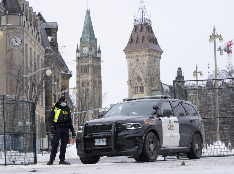A police officer mans a checkpoint near Parliament Hill, Wednesday, Feb. 23, 2022 in Ottawa. Ottawa protesters who vowed never to give up are largely gone, chased away by police in riot gear in what was the biggest police operation in the nation’s history. (Adrian Wyld /The Canadian Press via AP)