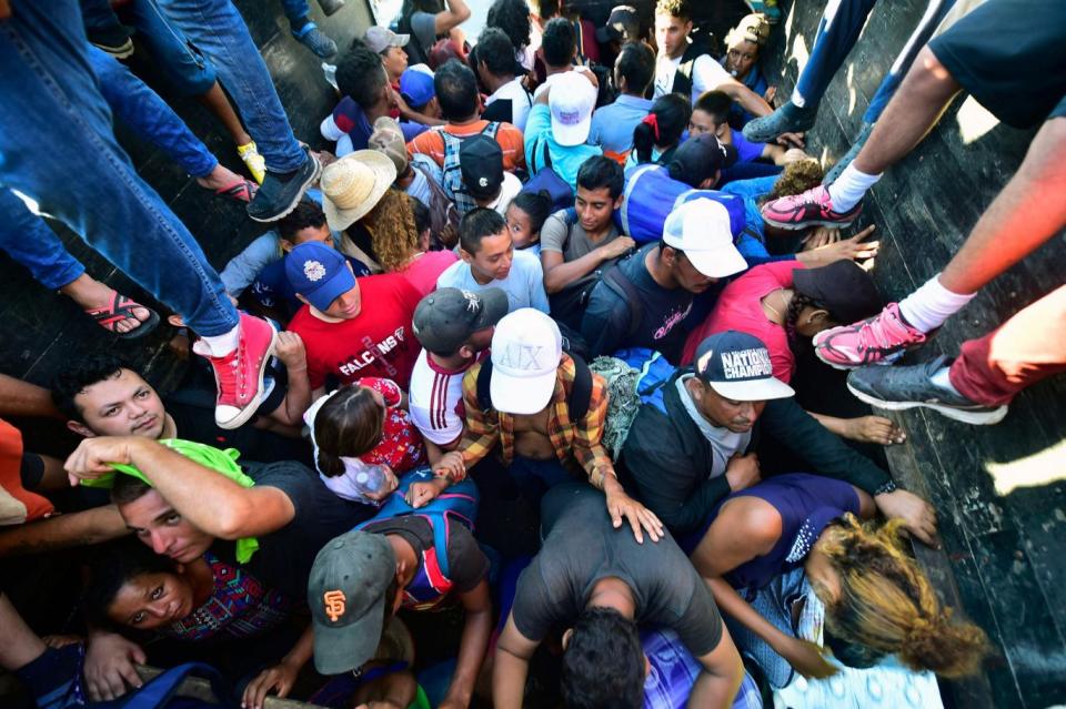 Rights groups say immigrants from the migrant caravan, like the ones pictured here, are being forced to wait weeks to present themselves for asylum (AFP/Getty Images)