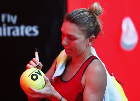 Tennis - Australian Open - Quarterfinals - Rod Laver Arena, Melbourne, Australia, January 24, 2018. Simona Halep of Romania signs autographs after winning against Karolina Pliskova of Czech Republic. REUTERS/Edgar Su