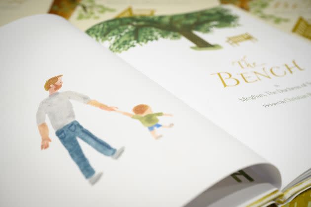 An illustration of a father and son inside a copy of Meghan Markle's book 