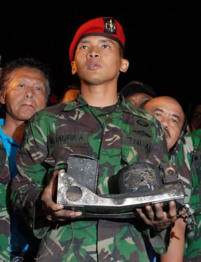 An Indonesian military officer displays the charred black box of the Russian Sukhoi Superjet 100, Russia's first post-Soviet civilian aircraft, at the search and rescue base in Cijeruk near Mount Salak