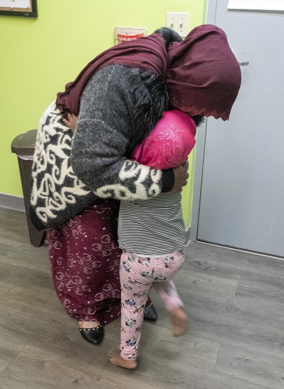 Hinda Abdullahi hugs her daughter before going to a second part of a child care class at Family and Child Care Resources of Northeast Wisconsin in Green Bay.
