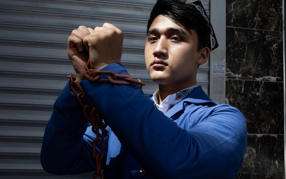 A Uighur activist wears plastic chains and an imitation prison uniform ahead of a demonstration outside the Chinese embassy in Istanbul, Turkey - Sam Tarling for The Telegraph 