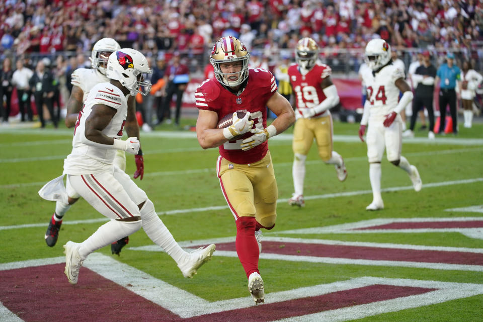 San Francisco 49ers running back Christian McCaffrey, middle, catches a touchdown pass against the Arizona Cardinals during the first half of an NFL football game Sunday, Dec. 17, 2023, in Glendale, Ariz. (AP Photo/Matt York)