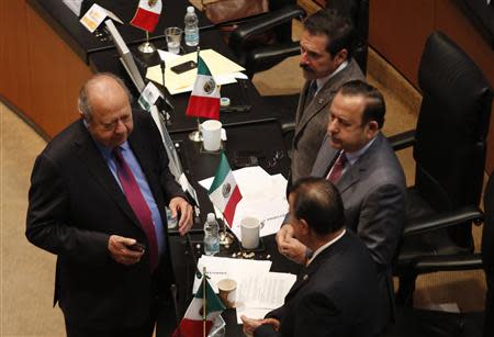 Carlos Romero Deschamps (L), senator and leader of the oil workers union of state oil monopoly Pemex, speaks with other senators before a debate on an energy reform bill at the Senate in Mexico City December 10, 2013. REUTERS/Henry Romero