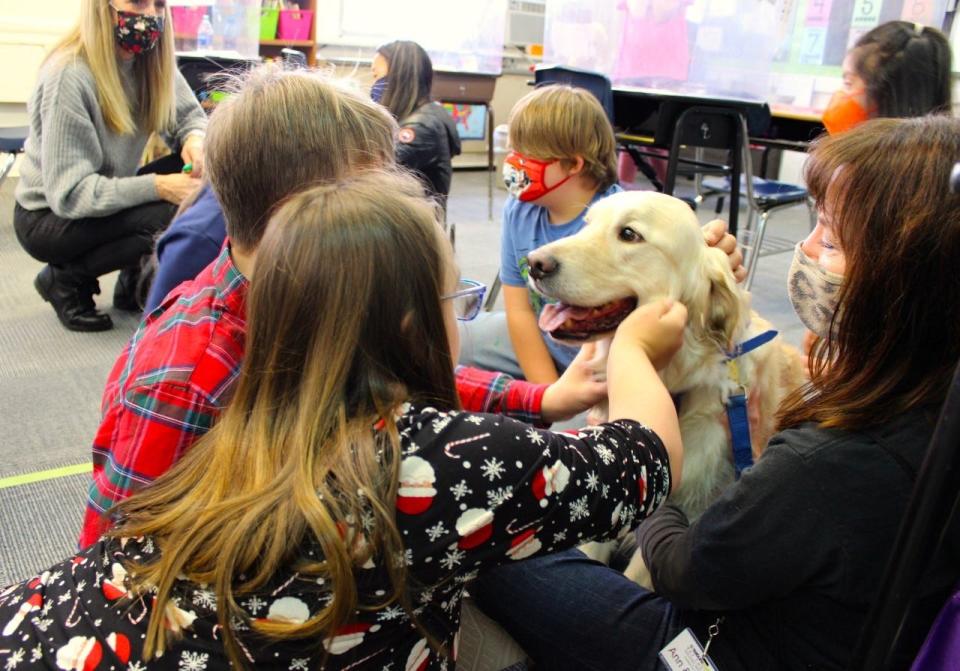 Ann Cox (right) and her therapy dog Augie from Creature Comfort Pet Therapy visit with children from the Education, Careers and Lifelong Community of Chatham in December 2021