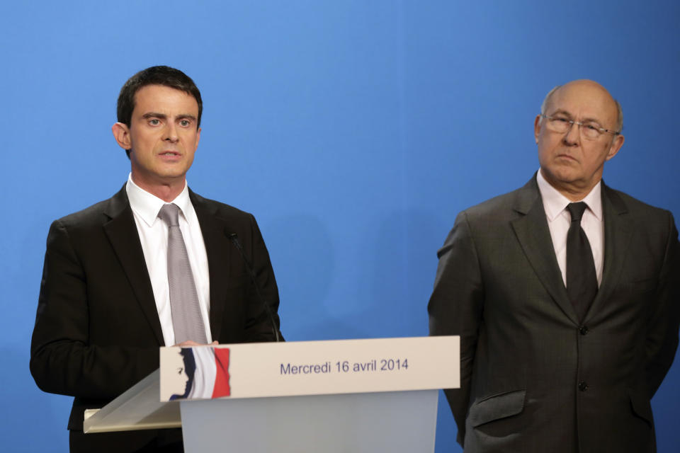 French Prime Minister Manuel Valls delivers a statement while Finance minister Michel Sapin, right, after the weekly cabinet meeting at the Elysee Palace in Paris, Wednesday, April 16, 2014. Valls provided details of the government's plan to reduce public spending by 50 billion euros ($ 69 billion) and reiterated that France would honor its European commitments on deficit reduction. (AP Photo/Philippe Wojazer, Pool)