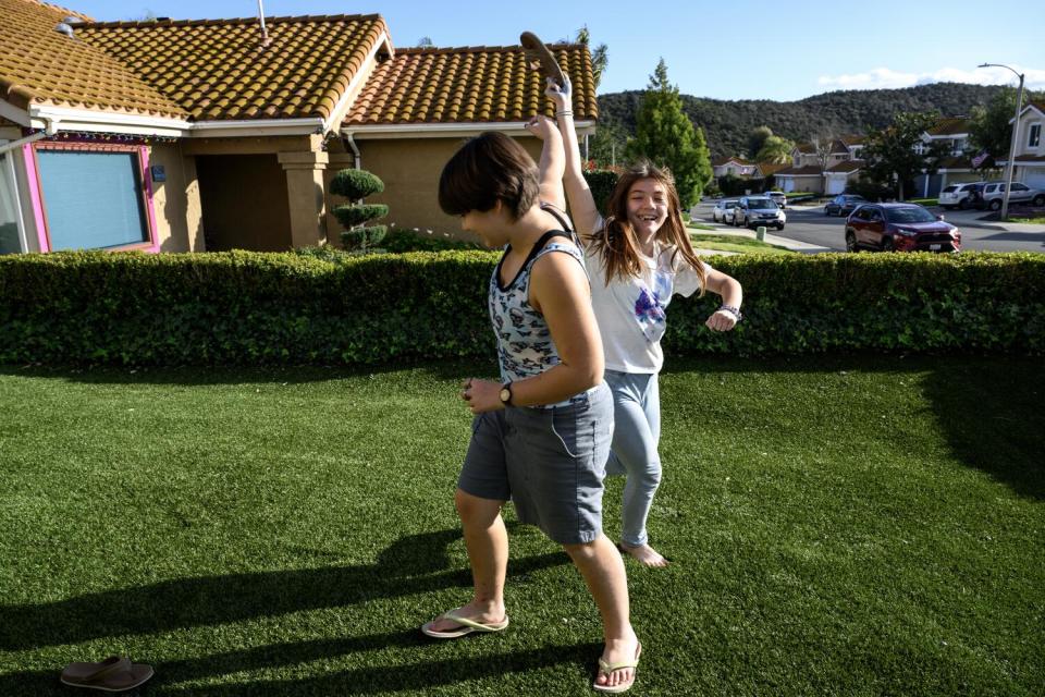 Siblings Kestrel Wineman, now 13, left, and Rosie Wineman, 11, goof around in their front yard in Murrieta.