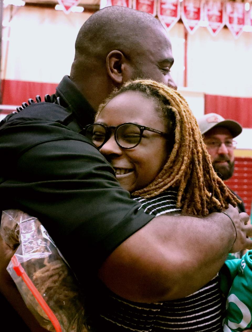 Maria Warrick-Allen gets a hug from SRO Anthony Bragg after cutting her hair for charity during Riverdale High School's annual Brave the Shave fundraiser to benefit the St. Baldrick's Foundation on Friday, April 8, 2022,