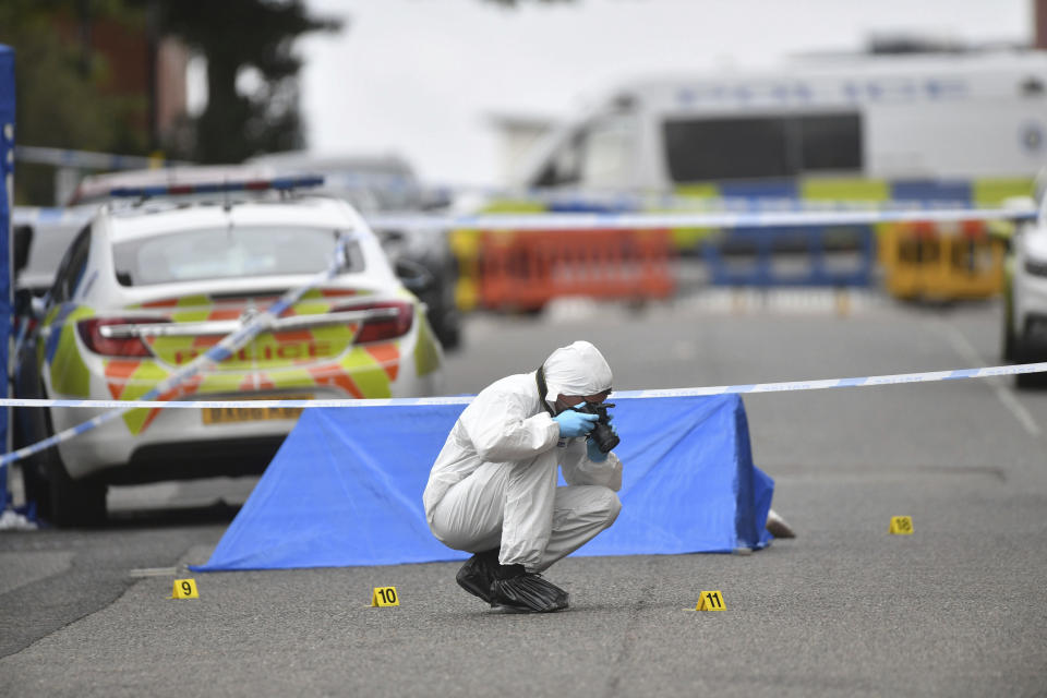 A police forensics officer taking photographs in Irving Street, in Birmingham after a number of people were stabbed in the city centre, Sunday, Sept. 6, 2020. British police say that multiple people have been injured in a series of stabbings in a busy nightlife area of the central England city of Birmingham.(Jacob King/PA via AP)