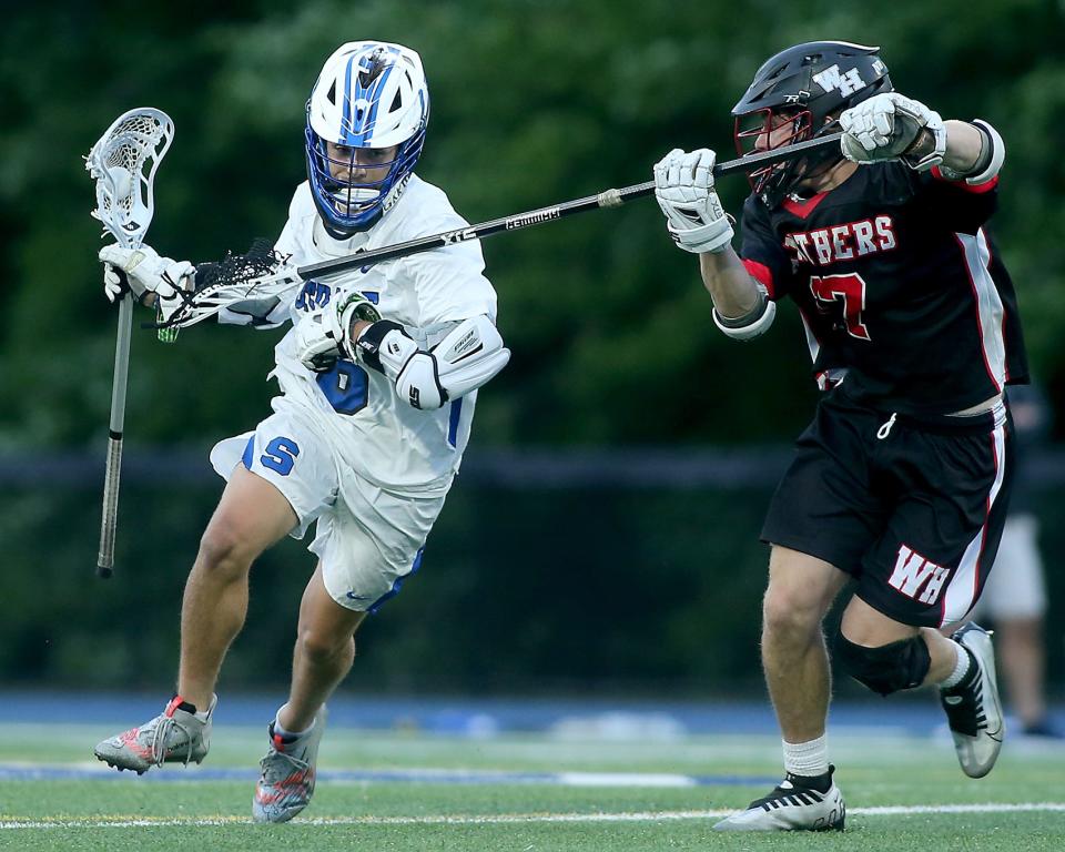 Scituate's Quinn DeCourcey brings the ball upfield while being defended by Whitman-Hanson's Will Frazier during second quarter action of their game against Whitman-Hanson in the Round of 32 of the Division 2 state tournament at Scituate High School on Tuesday, June 7, 2022. 