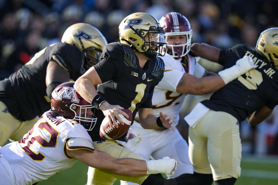 Minnesota defensive lineman Danny Striggow (92) sacks Purdue quarterback Hudson Card (1) during the first half of an NCAA college football game in West Lafayette, Ind., Saturday, Nov. 11, 2023. (AP Photo/Michael Conroy)