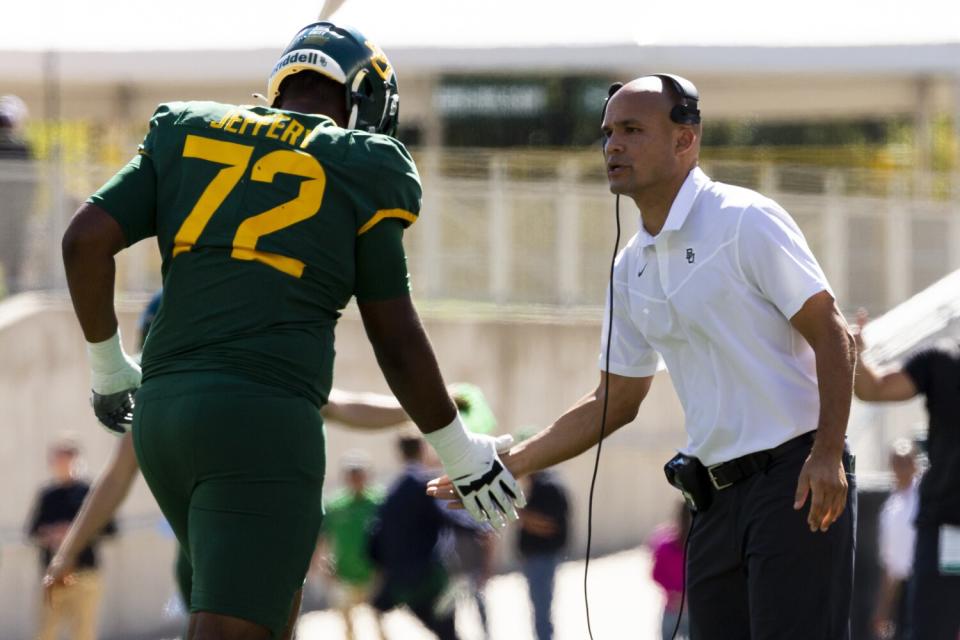 Baylor coach Dave Aranda congratulates offensive lineman Mose Jeffery.