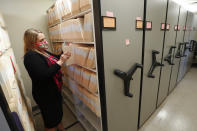 Jennifer Gottschalk, environmental health supervisor of the Toledo-Lucas County Health Department, retrieves a file in Toledo, Ohio, on Wednesday, June 24, 2020. She says the job is wearing on her. She has worked for months with hardly a day off. So many lab reports on COVID-19 cases came in that the office fax machine broke. And she fields countless angry phone calls amid community backlash over coronavirus restrictions. (AP Photo/Paul Sancya)