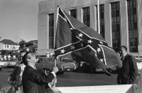 <p>Raymond Roberts (left) raises a large confederate flag on the back of a pickup truck across the street from the federal building in Meridian, Miss. on Monday, Oct. 9, 1967, where his brother Alton Wayne Roberts and 17 others went on trial on conspiracy charges in the 1964 slaying of three civil rights workers. (Photo: AP) </p>