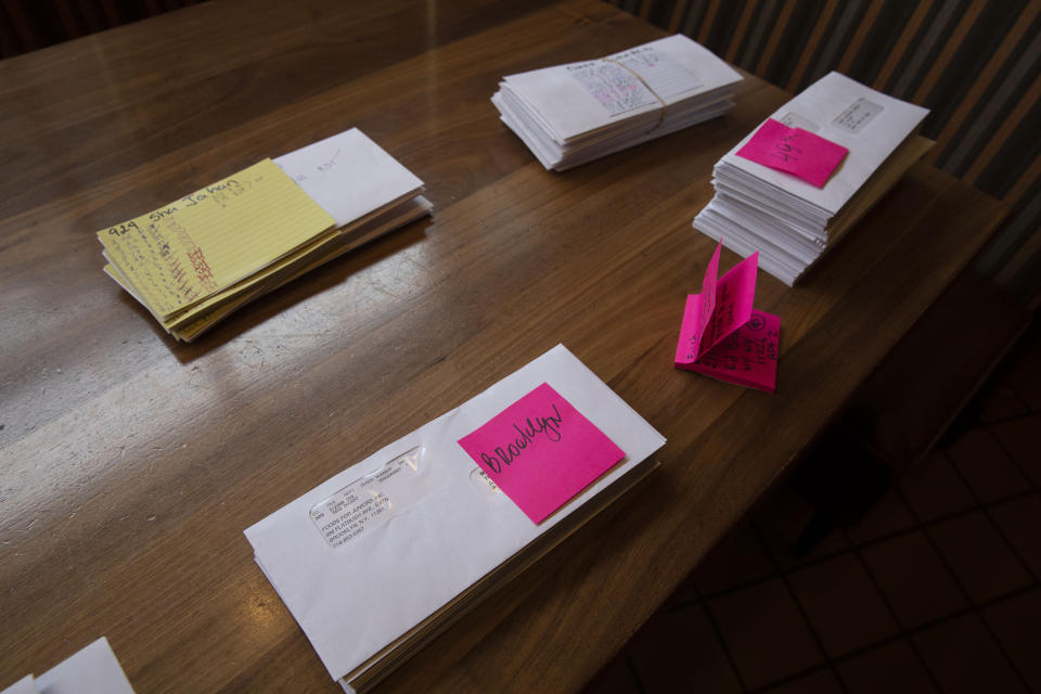 Paychecks are stacked on a table at Junior's Restaurant for distribution to employees, Thursday, March 19, 2020 in the Brooklyn borough of New York. The company has closed its four locations due to the coronavirus and is laying off 650 of 850 employees. (AP Photo/Mark Lennihan)