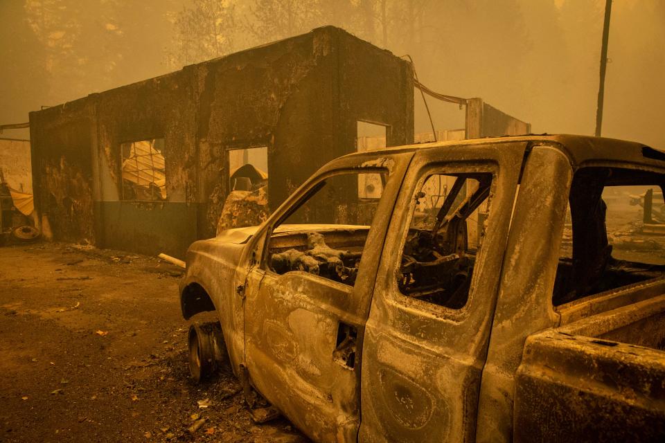 Burned out vehicles destroyed by the Holiday Farm Fire sit outside a shop in Nimrod, Ore. on Sept. 10, 2020.