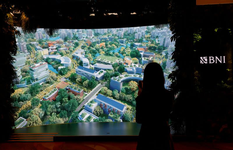 An attendee films a video presentation of Indonesia's new planned capital Nusantara, at Ecosperity Week in Singapore