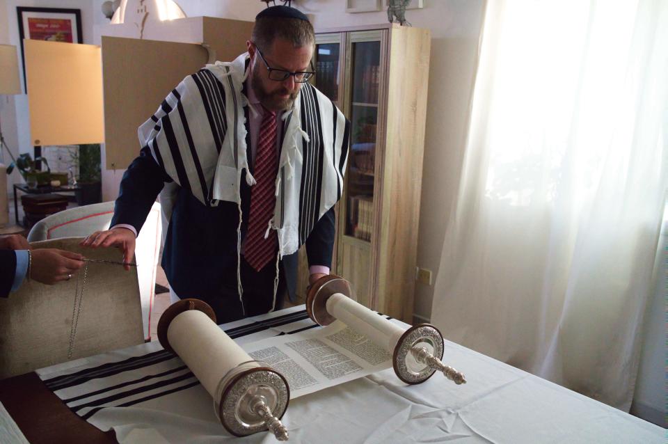 Alex Peterfreund, a co-founder of Dubai's Jewish community and its cantor, prepares to read from the Torah in Dubai, United Arab Emirates, Sunday, Aug. 16, 2020. Telephone service between the United Arab Emirates and Israel began working Sunday as the two countries opened diplomatic ties, part of a deal brokered by the U.S. that required Israel to halt its contentious plan to annex West Bank land sought by the Palestinians for a future state. (AP Photo/Jon Gambrell)